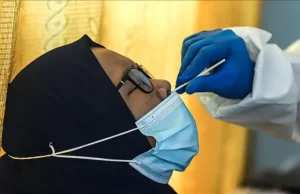 Endonezya'da bir ilaç firmasının çalışanları, kullanılmış virüa test çubuklarını yıkadıktan